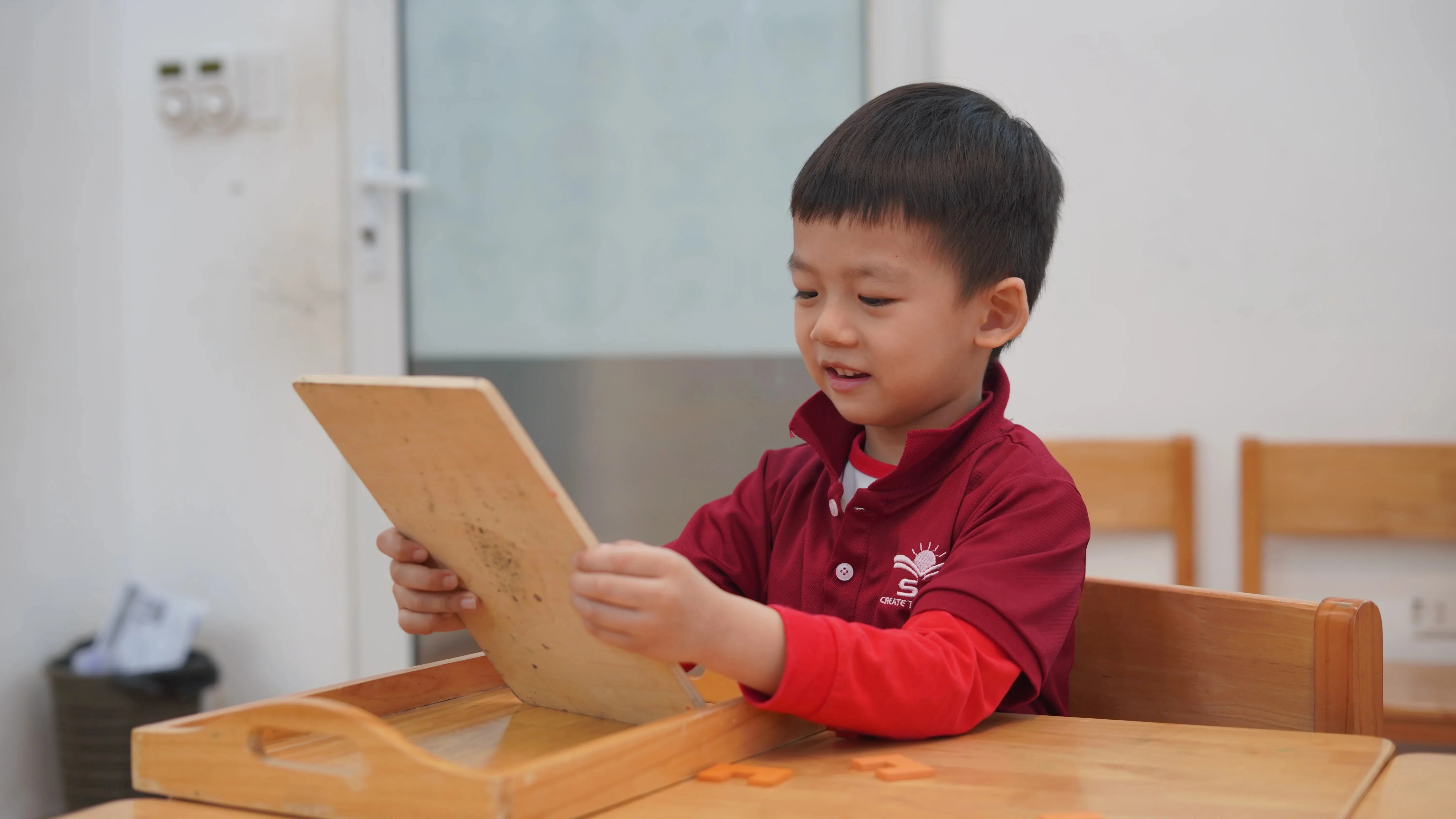 Trẻ ECE tập trung với giáo cụ gỗ